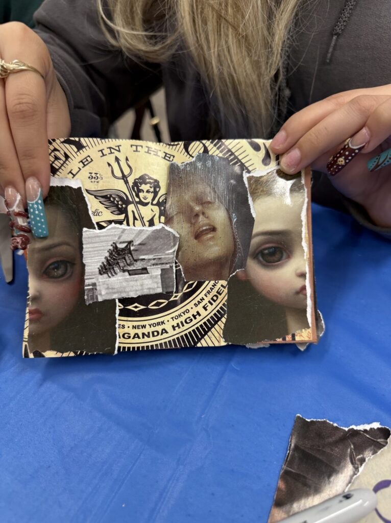 A participant holding up their finished collage zine