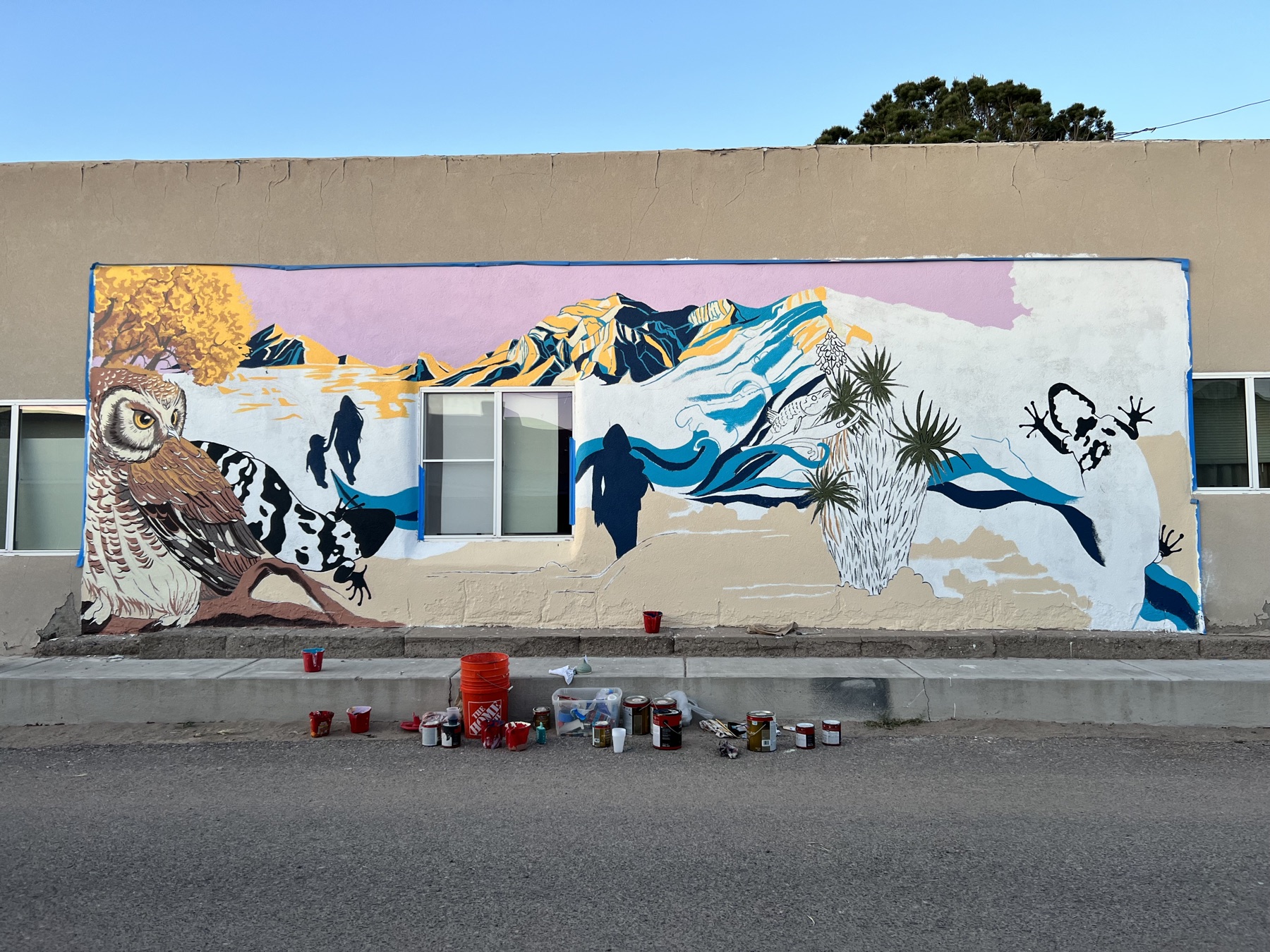 The Endangered Species mural in progress, paint cans lining the sidewalk